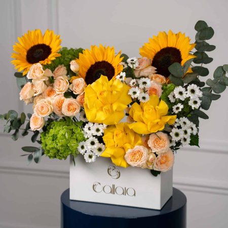 Bright bouquet of sunflowers, yellow roses, peach roses, white daisies, and eucalyptus in a Callaia-branded white box, perfect for same-day flower delivery in Dubai and the UAE.